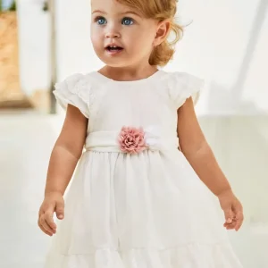 vestido ceremonia con fajin, y olan en la falda color blanco y flor rosa